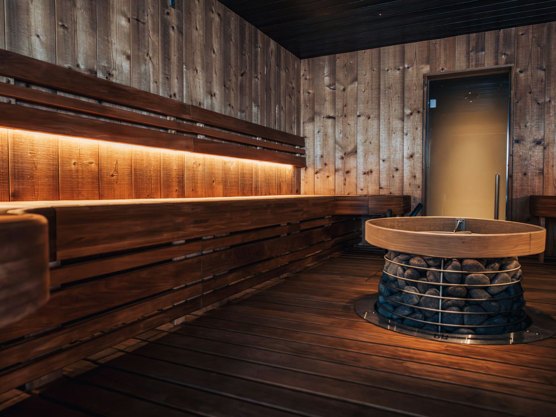 Storsalen, a long wooden sauna with a round stove in the middle