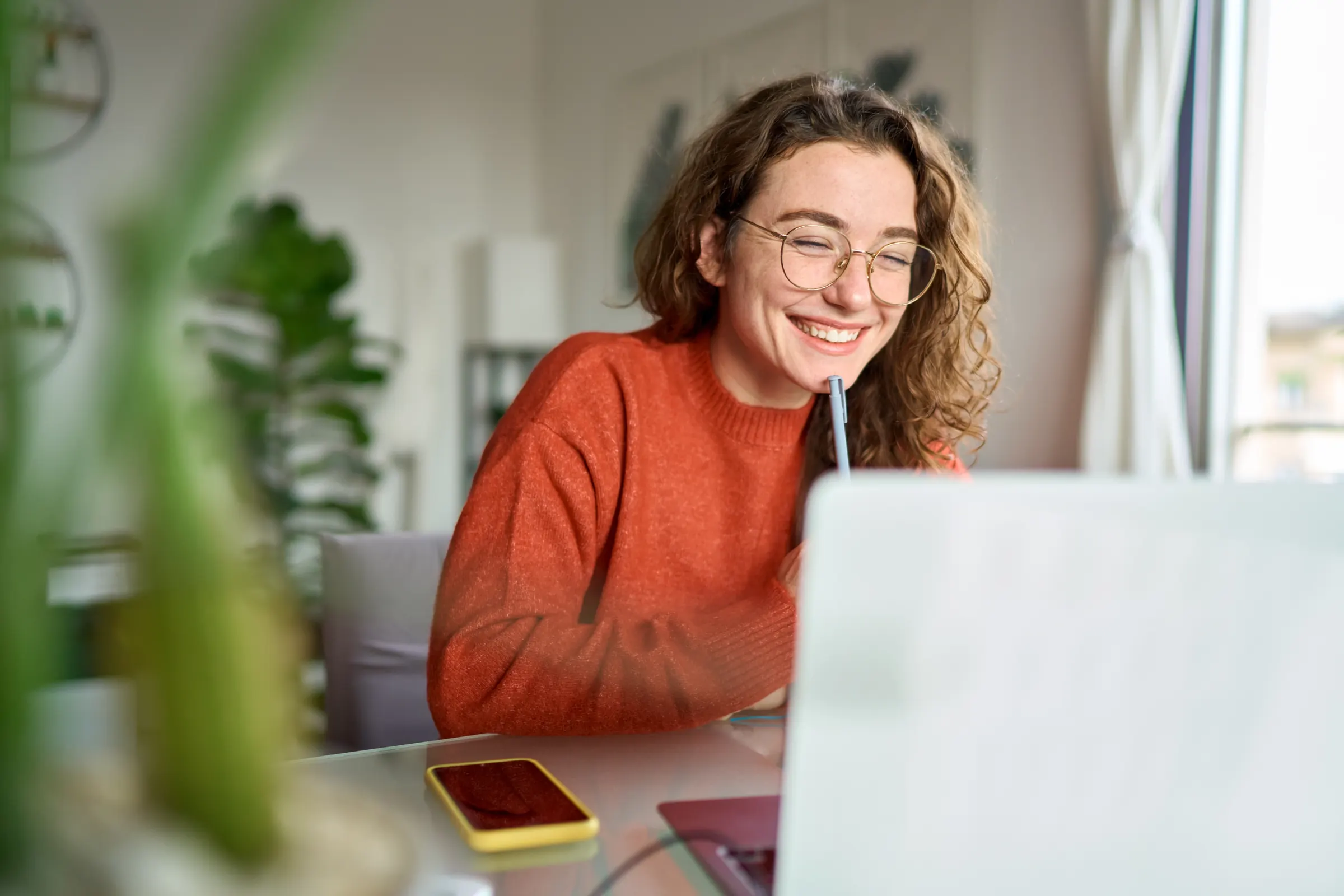 Student smiling while studying at her laptop