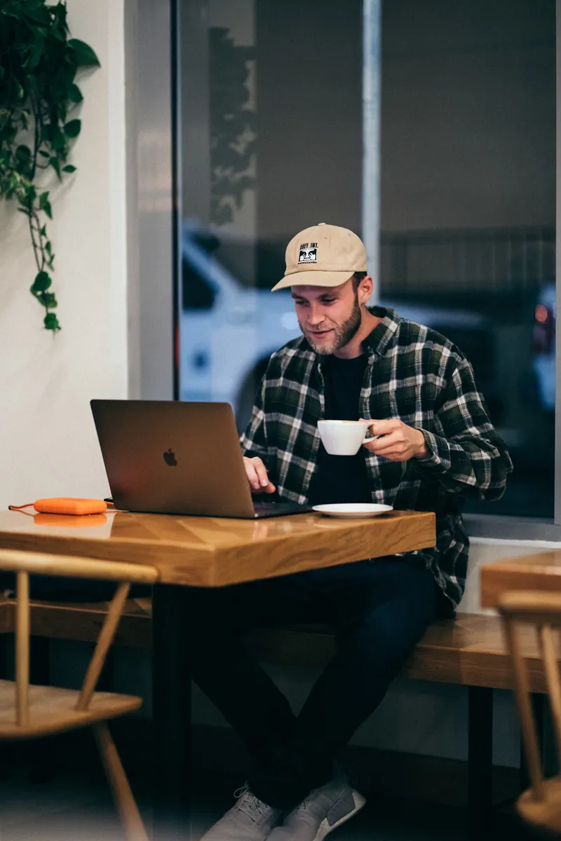 Learner with a coffee at a laptop