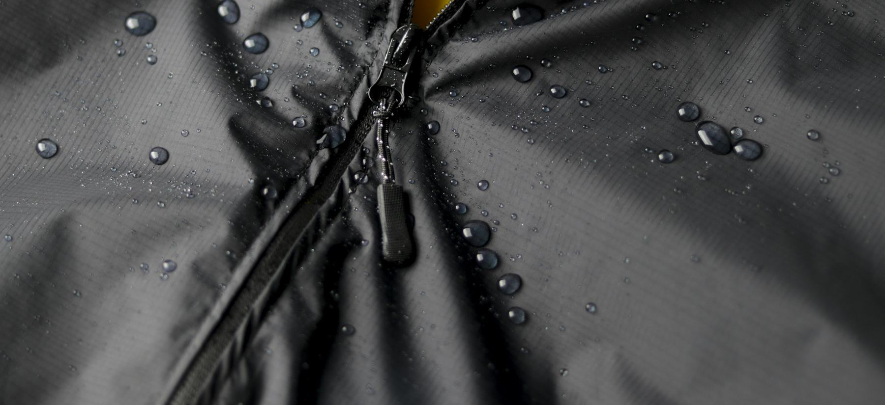 A taped zip on a wet rain jacket