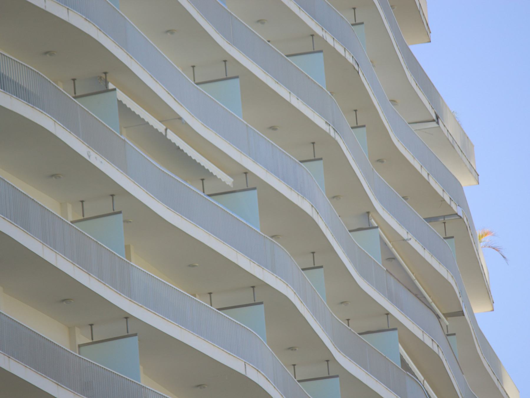 Curved white balconies against a blue sky